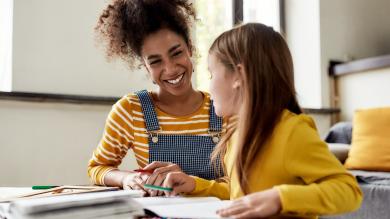 
		Child learns tutoring with a tutor at the kitchen table
	